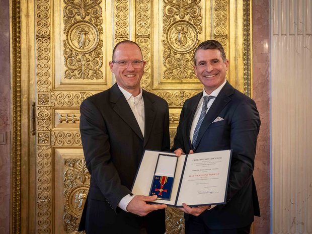 Dr. Marc-Michael Ventzke (links) erhält das Bundesverdienstkreuz von Bayerns Europaminister Eric Beißwenger (rechts/Foto: Bayerische Staatskanzlei).