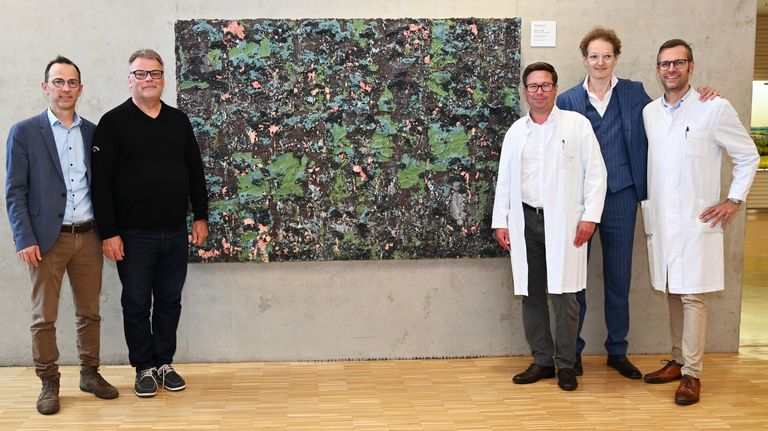Geschäftsführer Franz Huber (von links), Ärztlicher Direktor Prof. Dr. Oliver Rentzsch, Prof. Dr. Florian Jentzmik, Dr. Julian Krott und Prof. Dr. Martin Heuschmid vor dem Gemälde des Künstlers Patrick Rohner, das am Eingang zur Urologie einen neuen Ehrenplatz bekommen hat. 